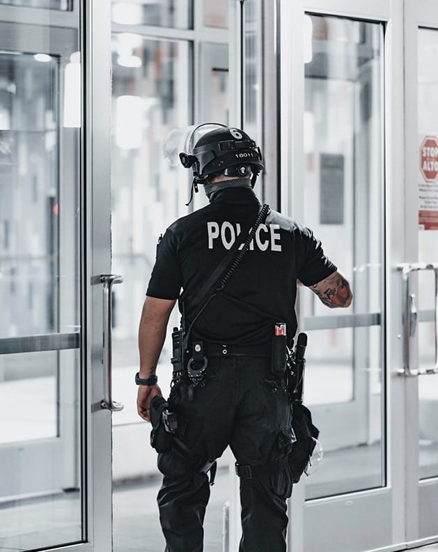 Police Officer walking out a door