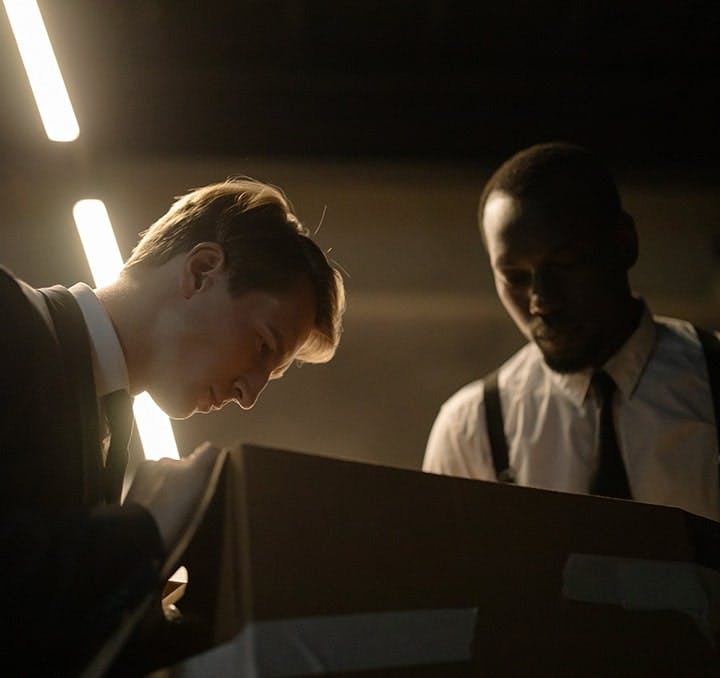 Two police detectives looking into a box of evidence